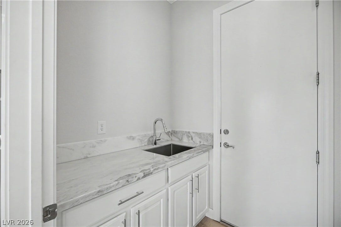 2073 Fountain City Street, Henderson, NV 89052 The laundry room also includes a utility sink with a pull-down faucet, marble countertop and extra cabinet storage below.