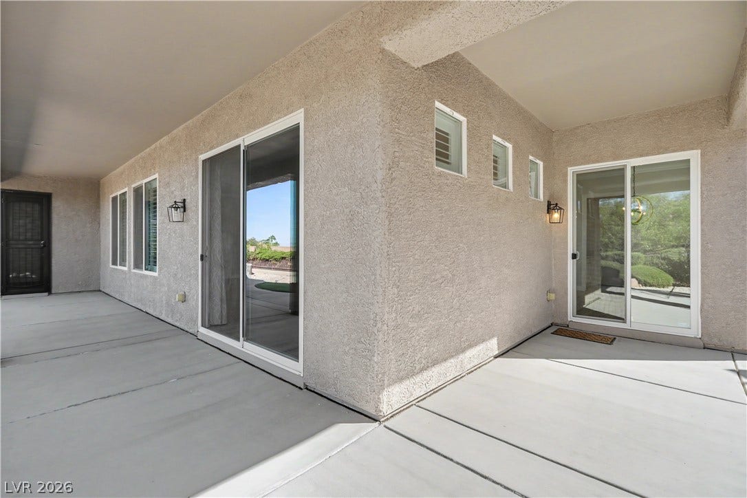 2073 Fountain City Street, Henderson, NV 89052 Covered patio wraps along the back of the home, with two sliding glass doors and a security screen door for easy access from multiple rooms.