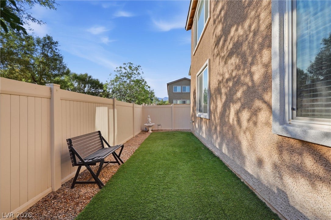 7057 Millers Run Street, North Las Vegas, NV 89084 An enclosed side yard features low-maintenance turf bordered by privacy fencing and stucco walls.
