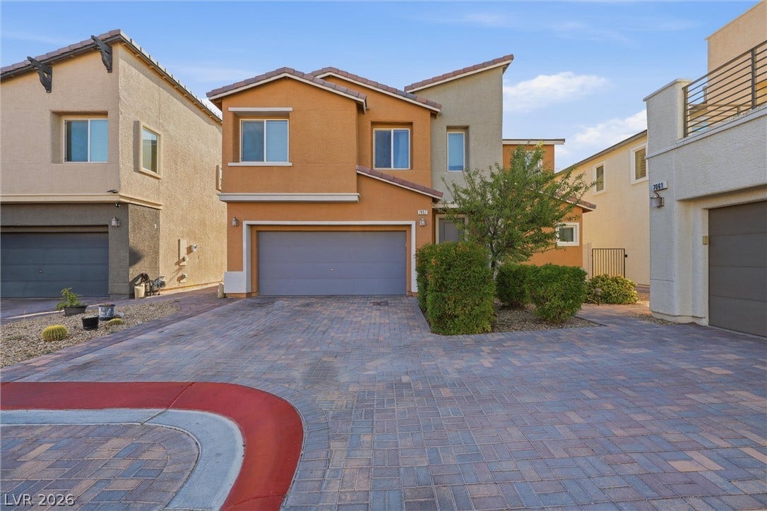 7057 Millers Run Street, North Las Vegas, NV 89084 An attractive paved driveway leads to a modern stucco home with a spacious garage.