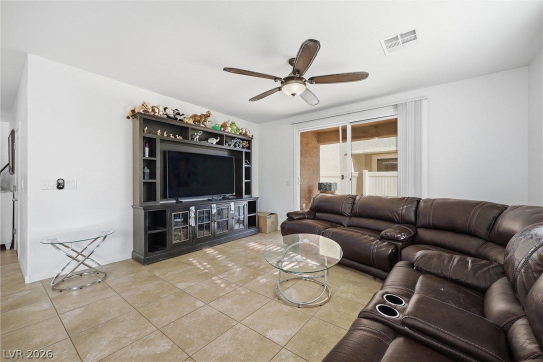 7057 Millers Run Street, North Las Vegas, NV 89084 Tile flooring and sliding glass doors leading outside define this comfortable gathering space.