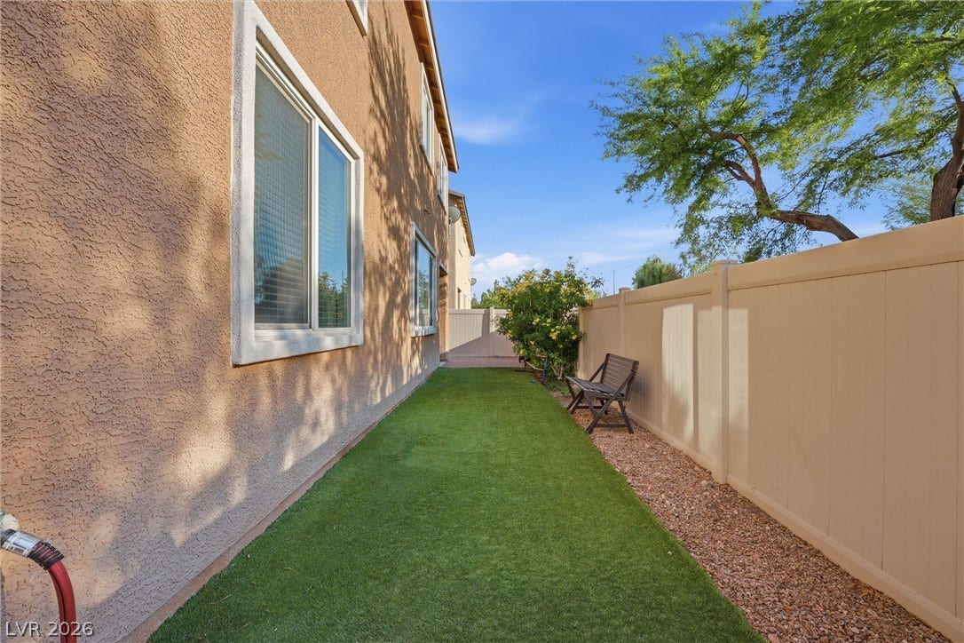 7057 Millers Run Street, North Las Vegas, NV 89084 A manicured lawn lines the stucco exterior of this multi-story residence.