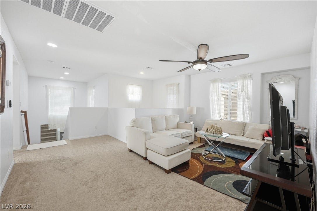7057 Millers Run Street, North Las Vegas, NV 89084 An open upstairs living area features wall-to-wall carpeting and recessed lighting.