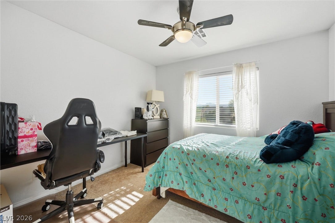 7057 Millers Run Street, North Las Vegas, NV 89084 Natural light streams across soft carpeted flooring in this comfortable secondary bedroom.
