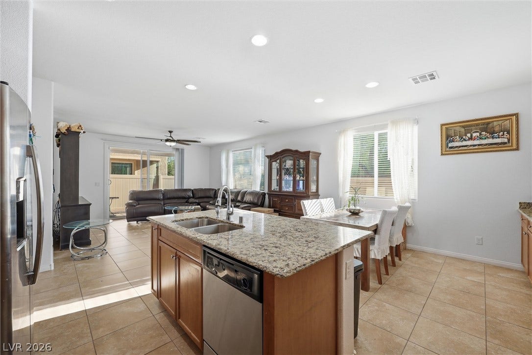 7057 Millers Run Street, North Las Vegas, NV 89084 Granite countertops and tile flooring anchor this airy, open-concept kitchen and dining area.
