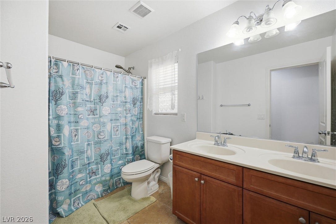 7057 Millers Run Street, North Las Vegas, NV 89084 A spacious double vanity and tile flooring highlight this classic guest bath layout.