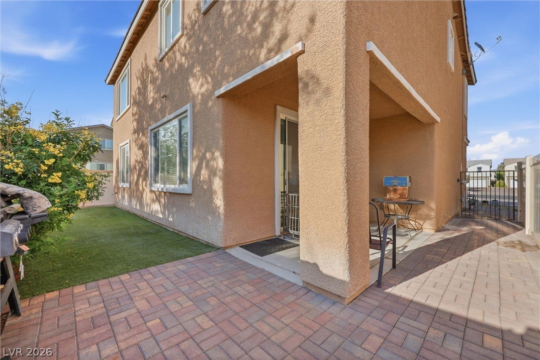 7057 Millers Run Street, North Las Vegas, NV 89084 Brick paver patio areas flank a covered entryway alongside the manicured grassy lawn.