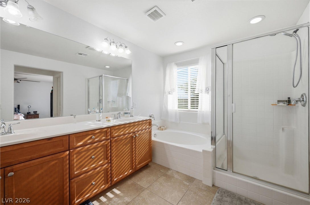 7057 Millers Run Street, North Las Vegas, NV 89084 Double vanities, a deep soaking tub, and a separate glass-enclosed shower maximize utility.
