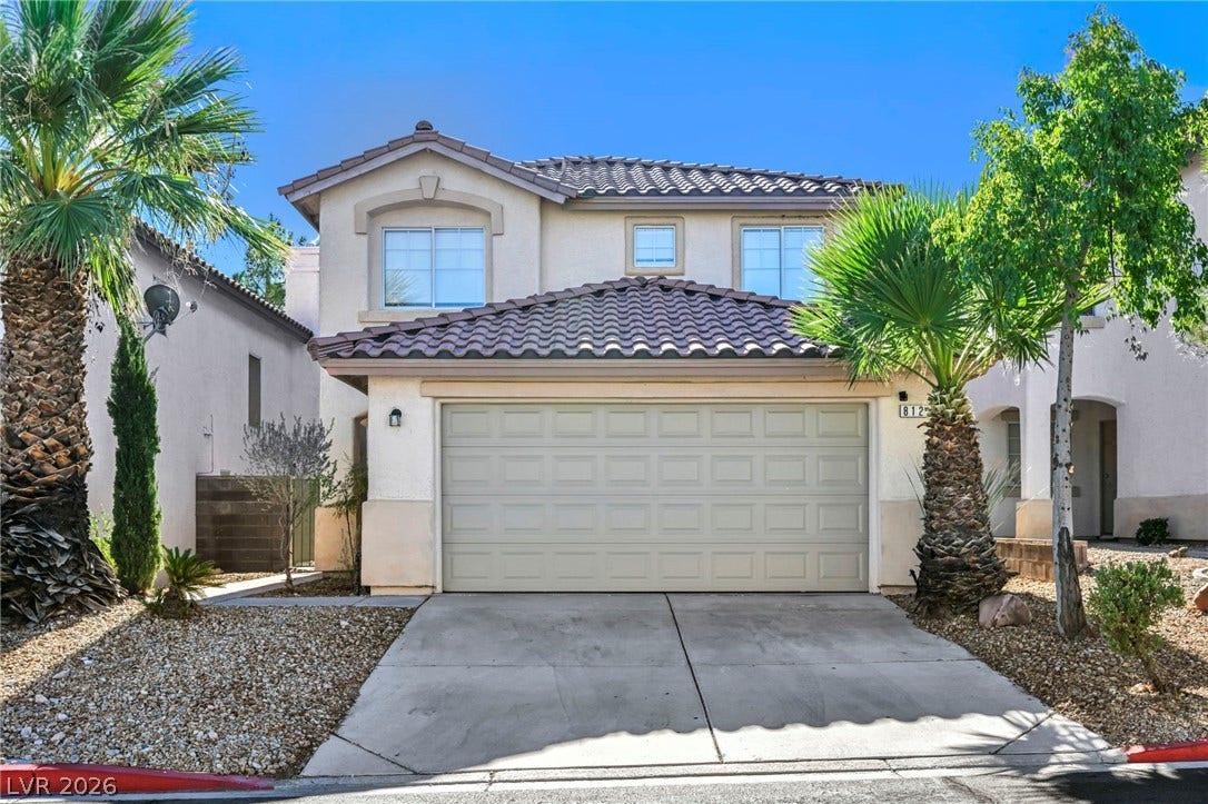 A classic two-story exterior showcases a tile roof and a spacious front-facing garage.
