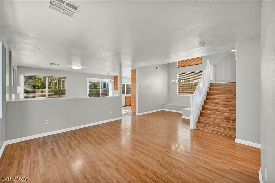 Polished wood floors and a classic staircase anchor this open-concept main living space.