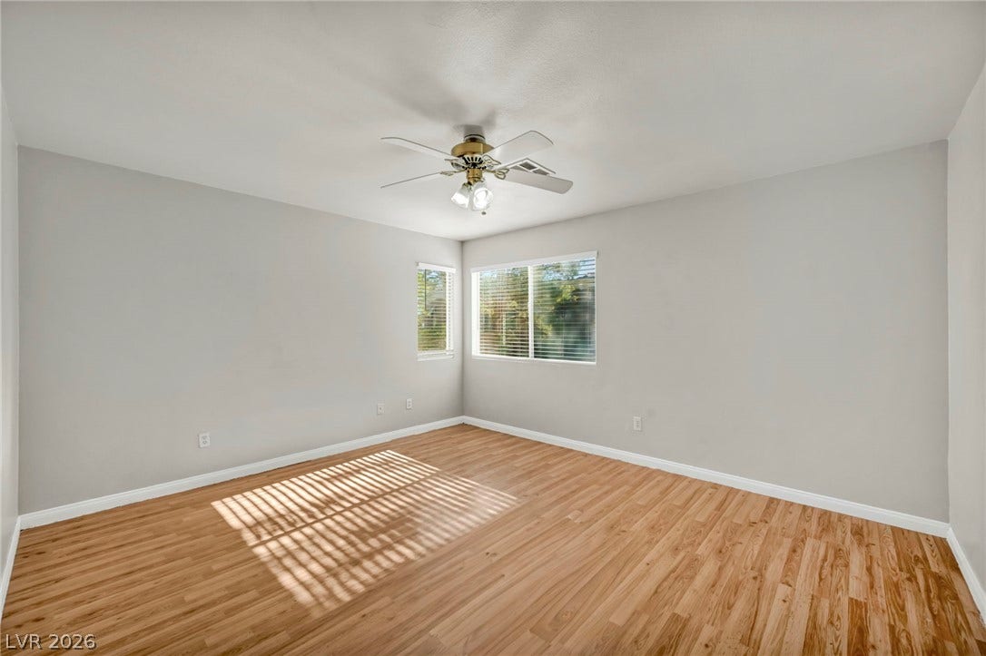 Warm wood flooring and clean walls create an inviting backdrop in this comfortable bedroom.