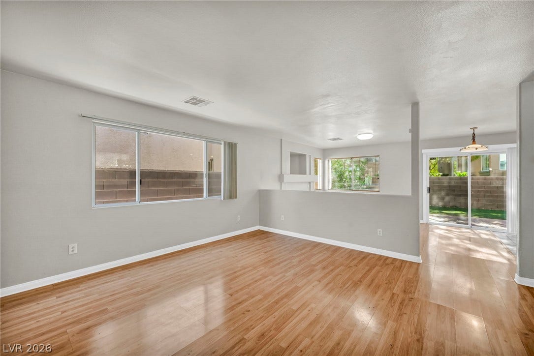 Gleaming wood flooring complements the airy, open flow of this versatile living space.