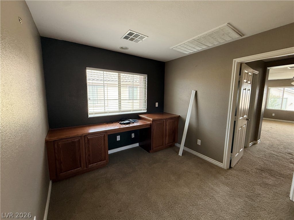 5904 Gold Horizon Street, North Las Vegas, NV 89031 Rich wood built-ins and soft carpeting anchor this versatile home office space.