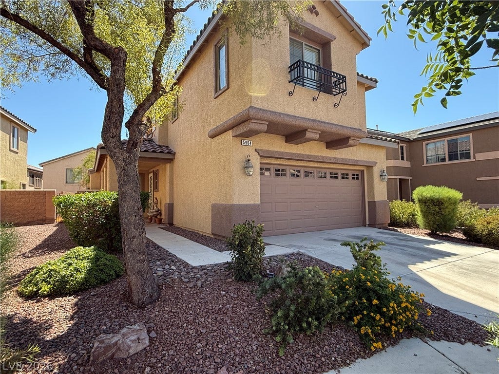 5904 Gold Horizon Street, North Las Vegas, NV 89031 Desert landscaping and a paved driveway lead to this two-story stucco home.
