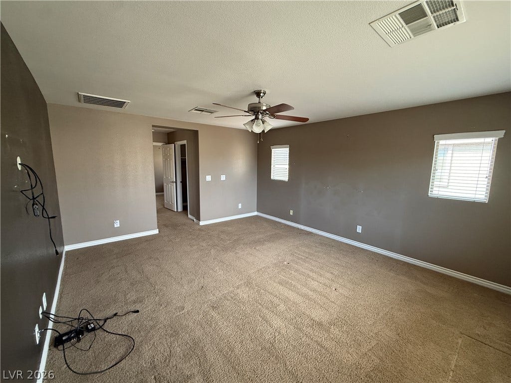 5904 Gold Horizon Street, North Las Vegas, NV 89031 A spacious room features soft neutral walls, classic baseboards, and plush carpeted flooring.