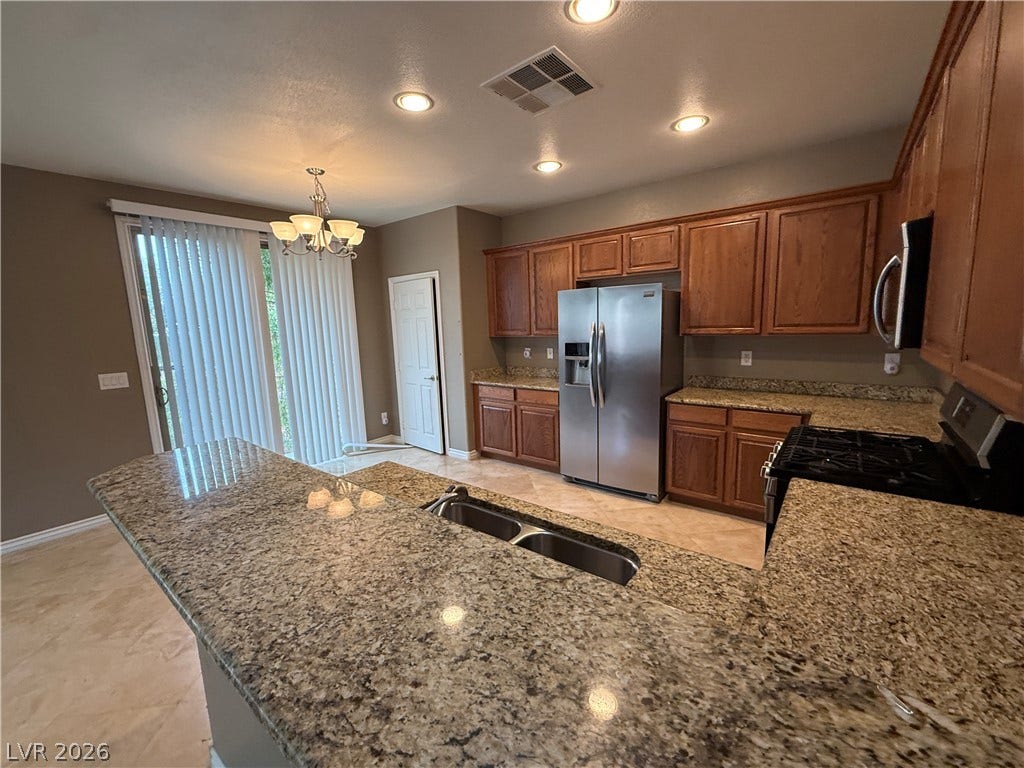 5904 Gold Horizon Street, North Las Vegas, NV 89031 Gleaming granite countertops pair beautifully with warm wood cabinetry in this functional space.