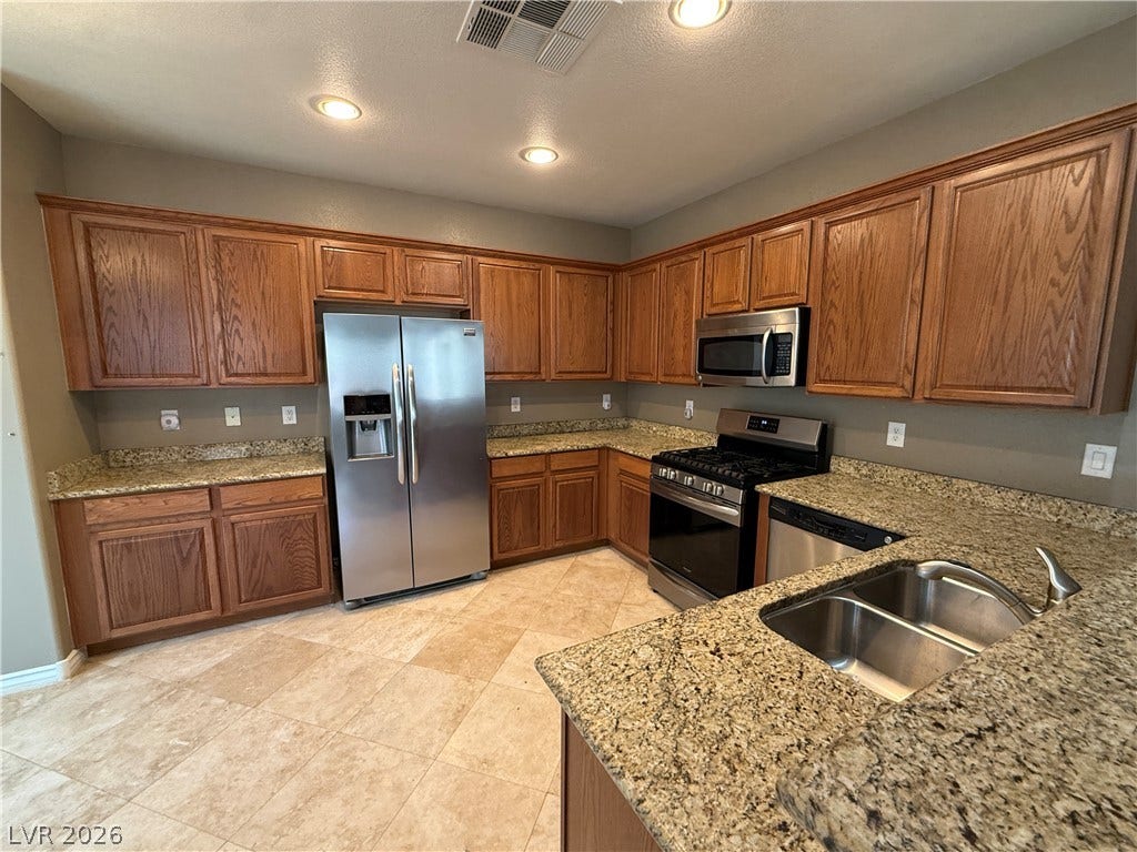 5904 Gold Horizon Street, North Las Vegas, NV 89031 Rich oak cabinetry complements granite countertops and modern stainless steel appliances.