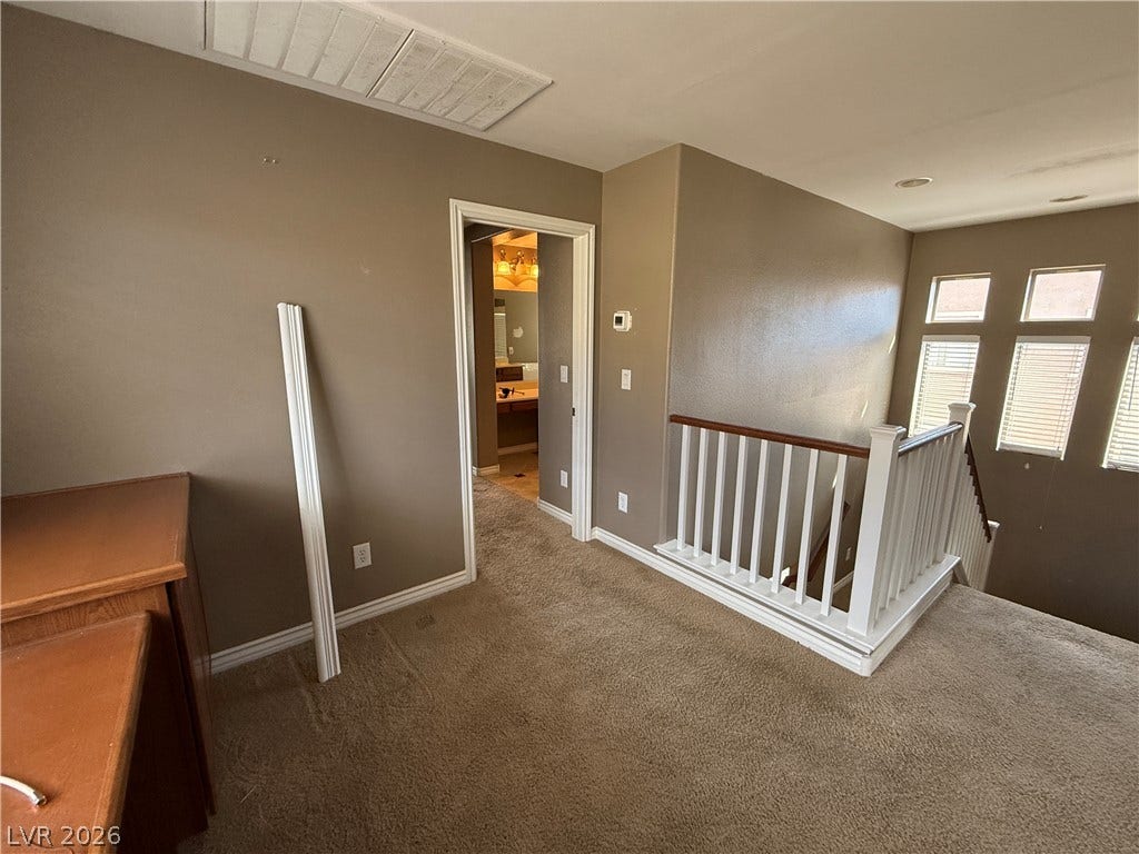 5904 Gold Horizon Street, North Las Vegas, NV 89031 An upper landing features plush carpeting and a wooden railing overlooking the lower level.