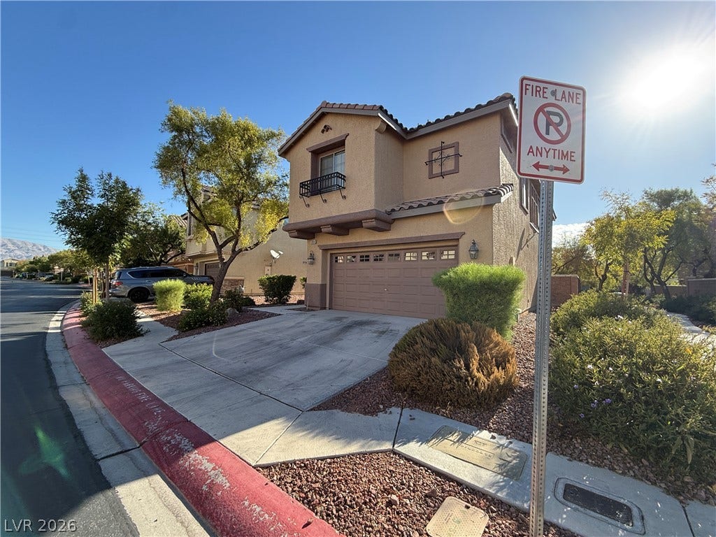 5904 Gold Horizon Street, North Las Vegas, NV 89031 A classic two-story exterior showcases a stucco finish, multi-paned garage door, and neat desert landscaping.