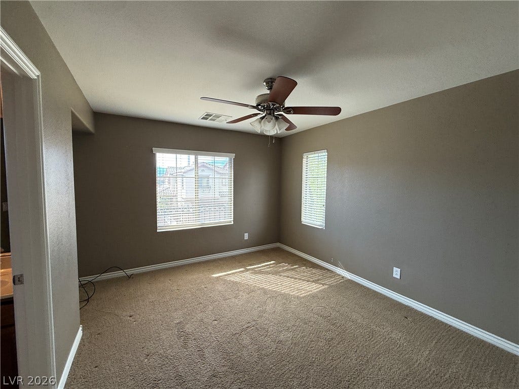 5904 Gold Horizon Street, North Las Vegas, NV 89031 Plentiful natural light streams across a carpeted bedroom with dual windows.