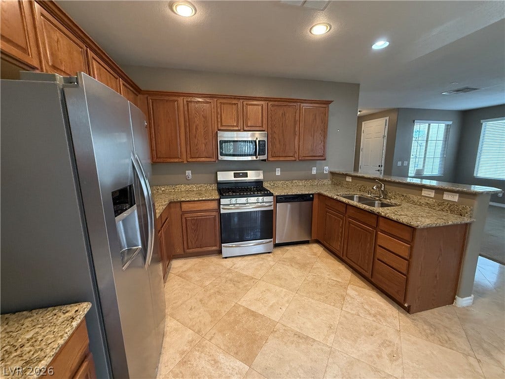 5904 Gold Horizon Street, North Las Vegas, NV 89031 Rich wood cabinetry and expansive granite countertops define this classic kitchen layout.
