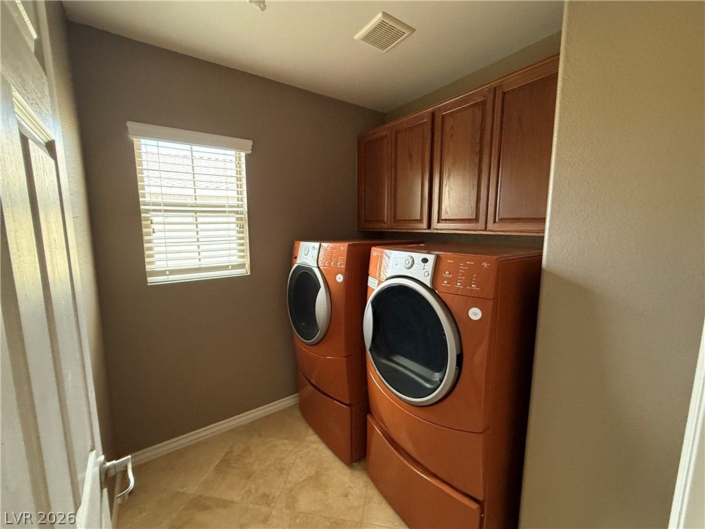 5904 Gold Horizon Street, North Las Vegas, NV 89031 Functional laundry utility space equipped with overhead cabinetry and tile flooring.