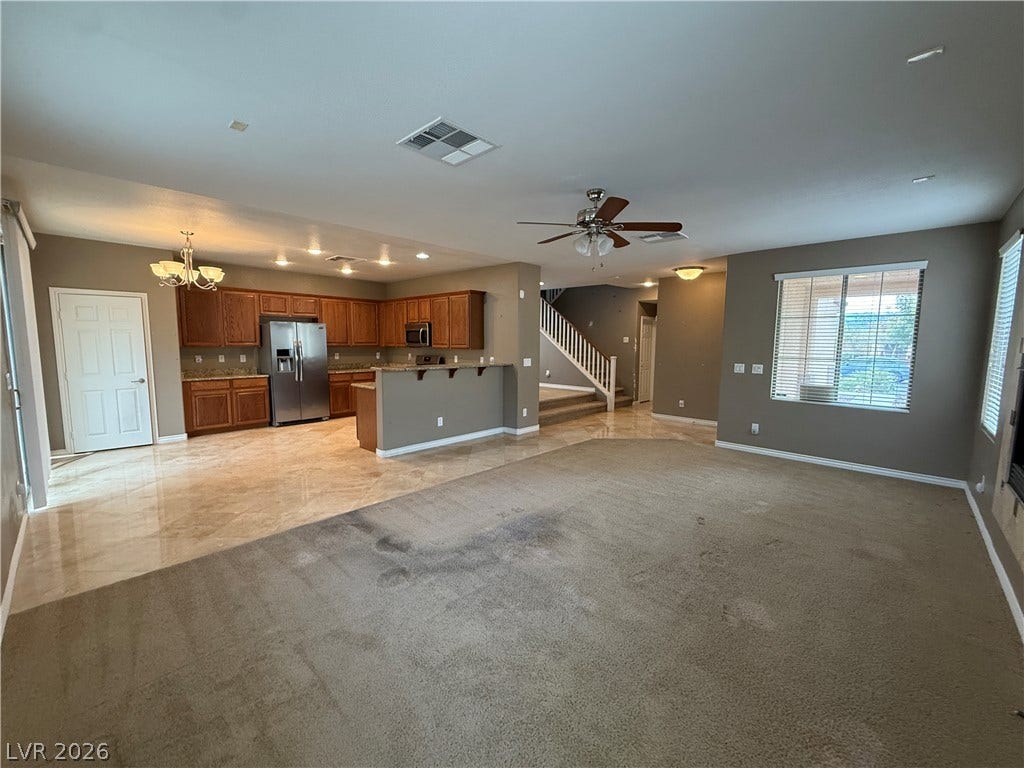 5904 Gold Horizon Street, North Las Vegas, NV 89031 An open layout connects the carpeted living space with a tiled kitchen and dining area.