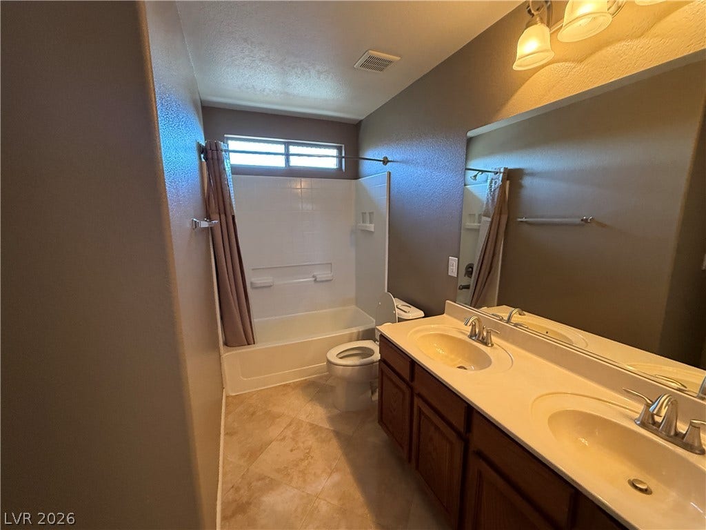 5904 Gold Horizon Street, North Las Vegas, NV 89031 A spacious double vanity and a classic tub shower highlight this functional bathroom space.
