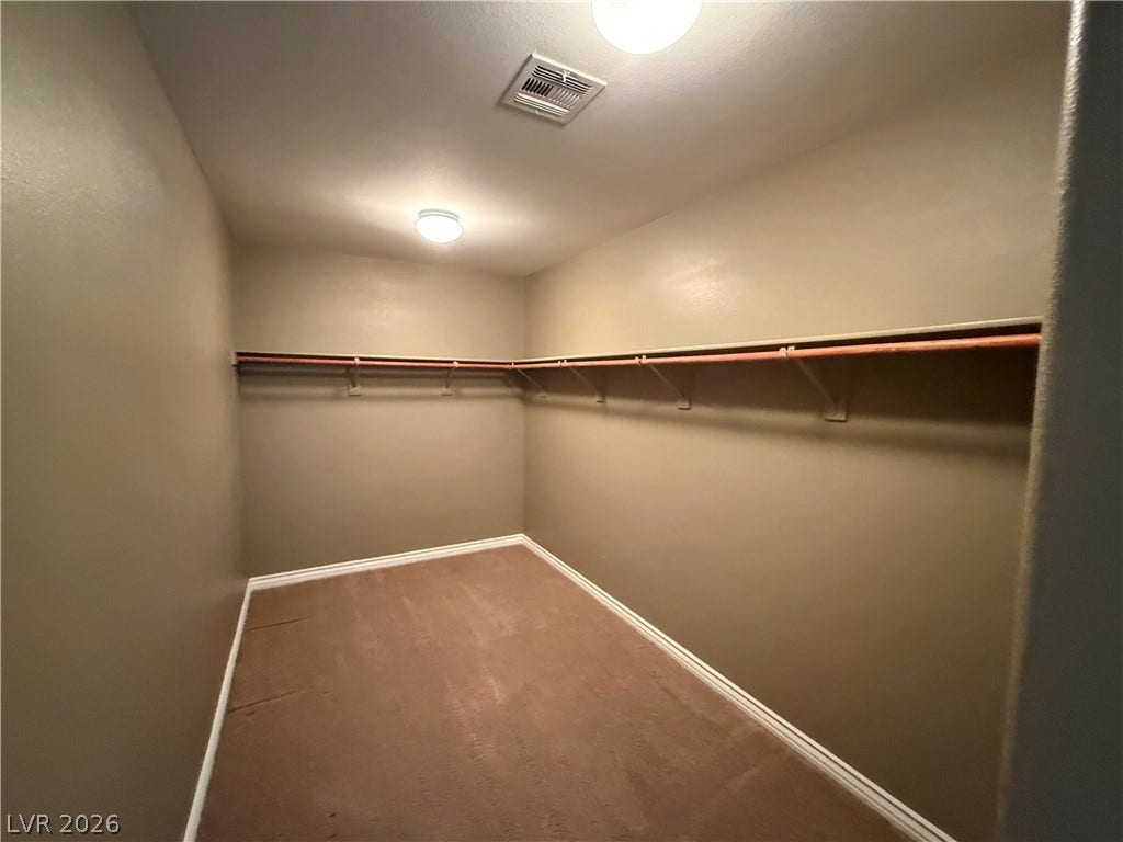 5904 Gold Horizon Street, North Las Vegas, NV 89031 Ample storage awaits in this walk-in closet featuring extensive hanging rods and wall-to-wall carpeting.