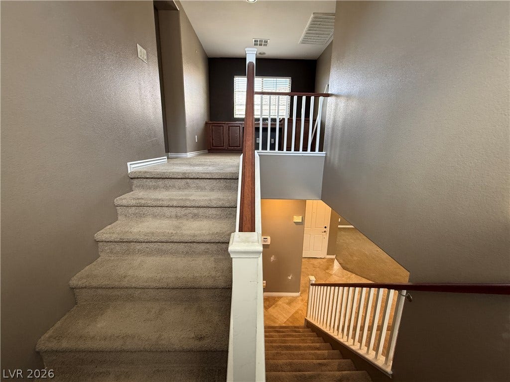 5904 Gold Horizon Street, North Las Vegas, NV 89031 Carpeted stairs with classic wooden handrails lead to a versatile upper-level landing space.