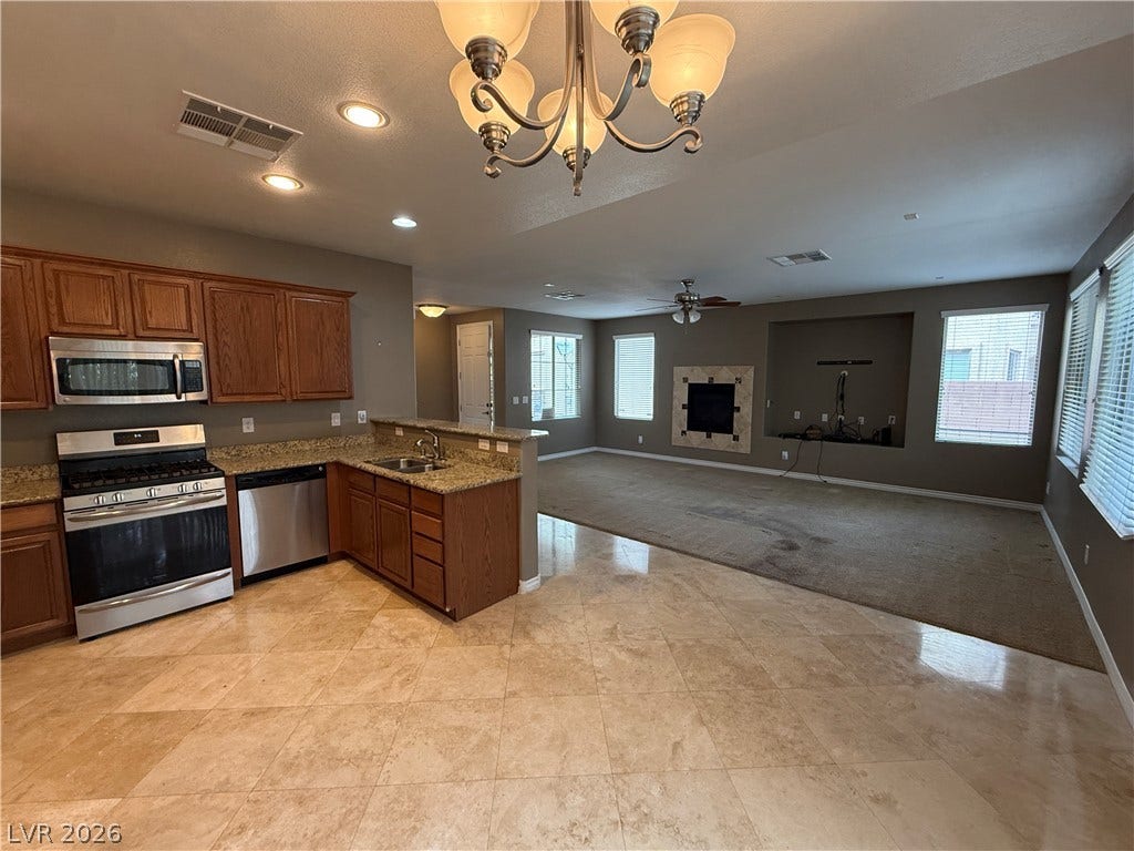 5904 Gold Horizon Street, North Las Vegas, NV 89031 Gleaming tile floors transition seamlessly into a comfortable carpeted living area with a cozy fireplace.
