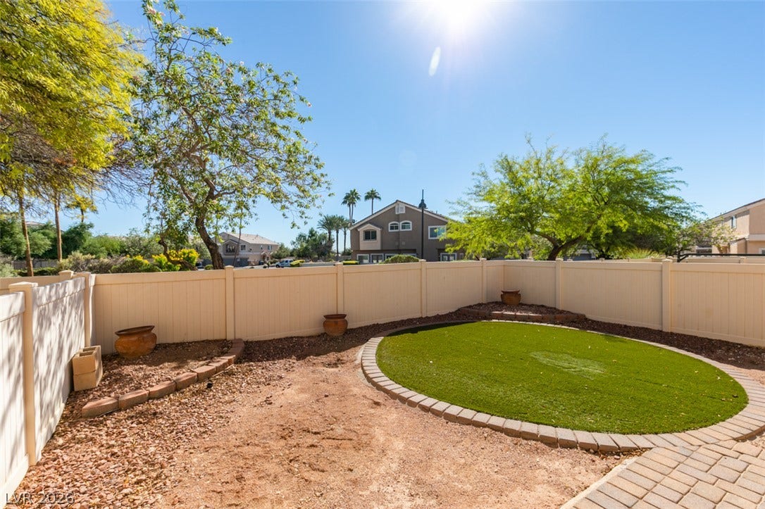 3612 Indigo Flower Street, #2, North Las Vegas, NV 89084 A fenced backyard features low-maintenance landscaping and a circular lawn design.