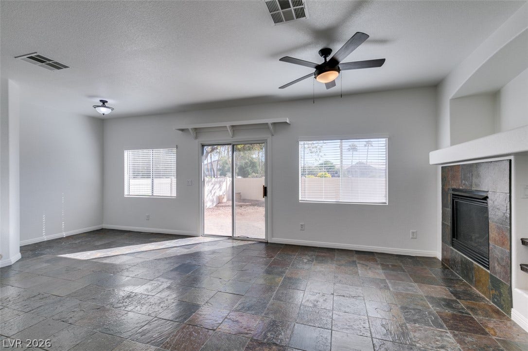 3612 Indigo Flower Street, #2, North Las Vegas, NV 89084 Natural stone tile floors and a fireplace with stone surround anchor this open living area.