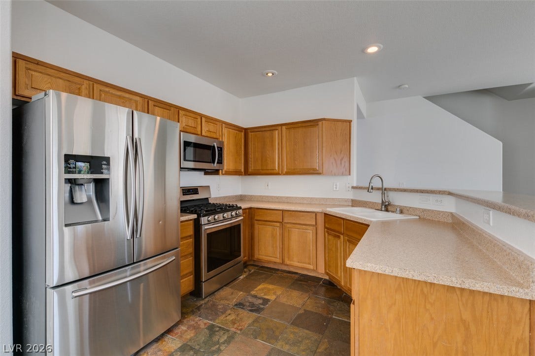 3612 Indigo Flower Street, #2, North Las Vegas, NV 89084 Natural wood cabinetry and textured stone tile flooring define this classic culinary space.