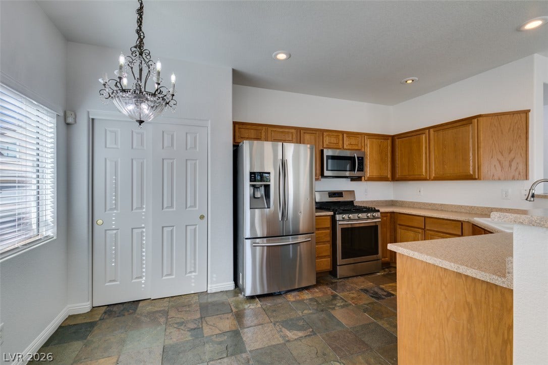 3612 Indigo Flower Street, #2, North Las Vegas, NV 89084 Natural stone tile flooring anchors this kitchen complete with classic oak cabinetry.