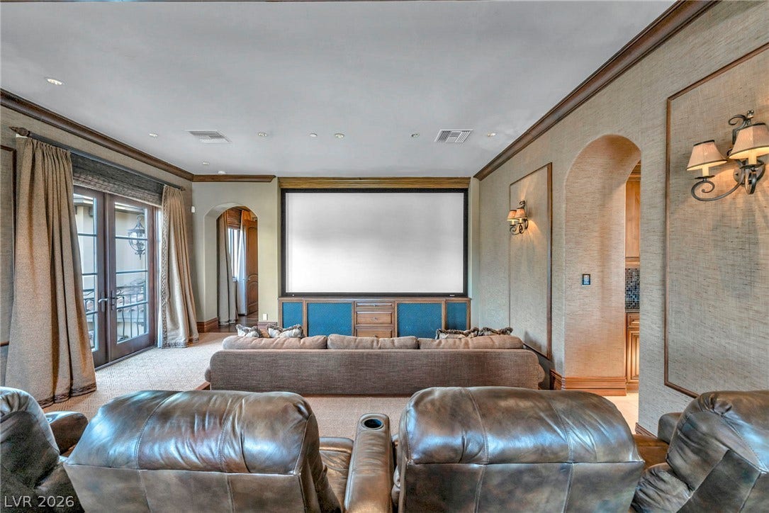 1793 Anelli Court, Henderson, NV 89012 Crown molding and textured walls frame a dedicated home theater setup with french doors.