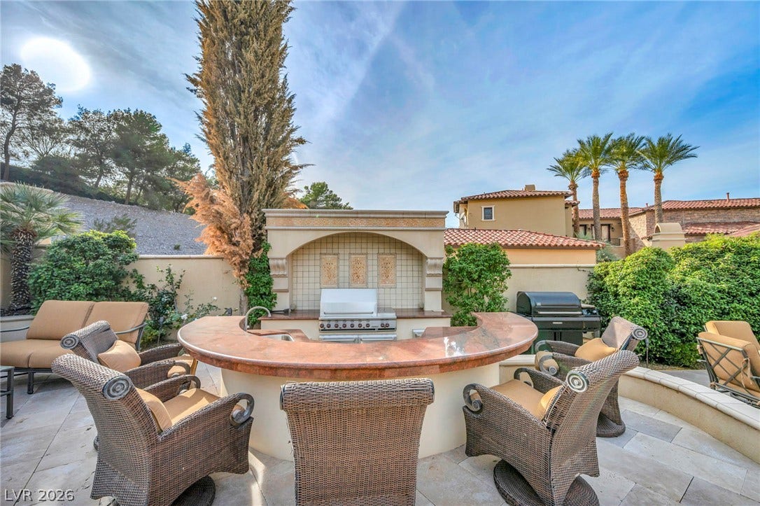 1793 Anelli Court, Henderson, NV 89012 An integrated outdoor kitchen and bar counter anchor this stone-paved patio space.