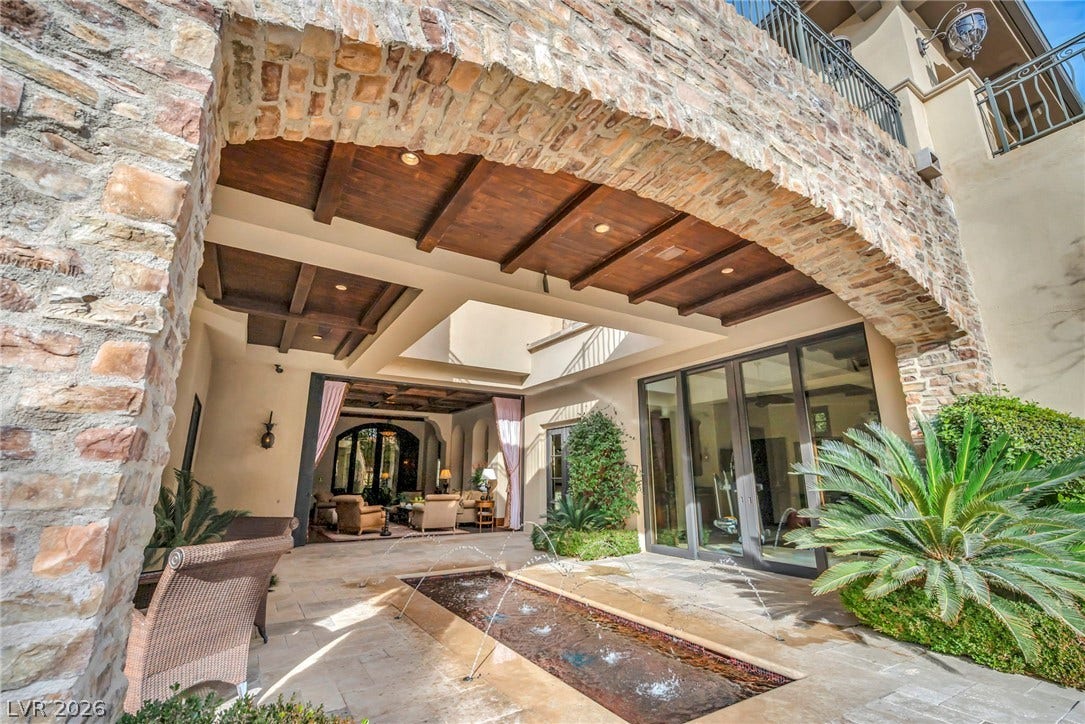 1793 Anelli Court, Henderson, NV 89012 A magnificent stone archway frames a stone-paved courtyard complete with a tranquil water fountain feature.