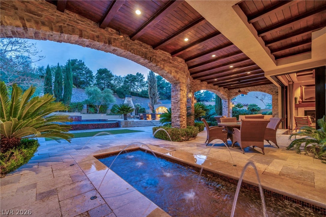 1793 Anelli Court, Henderson, NV 89012 Stone arches and timber ceilings frame this luxurious outdoor living area with water features.