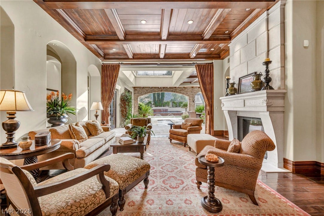 1793 Anelli Court, Henderson, NV 89012 A grand stone fireplace and rich wood-paneled ceiling elevate this elegant living area.