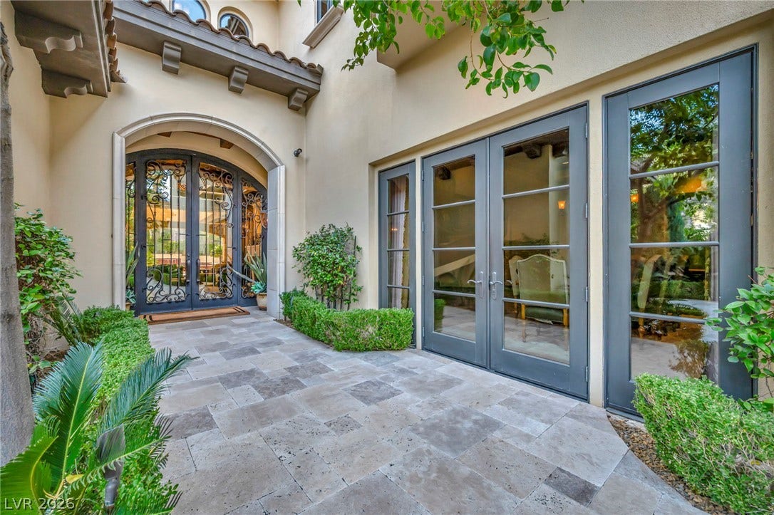 1793 Anelli Court, Henderson, NV 89012 Elegant stone pavers guide the way to a majestic arched entry and classic French doors.