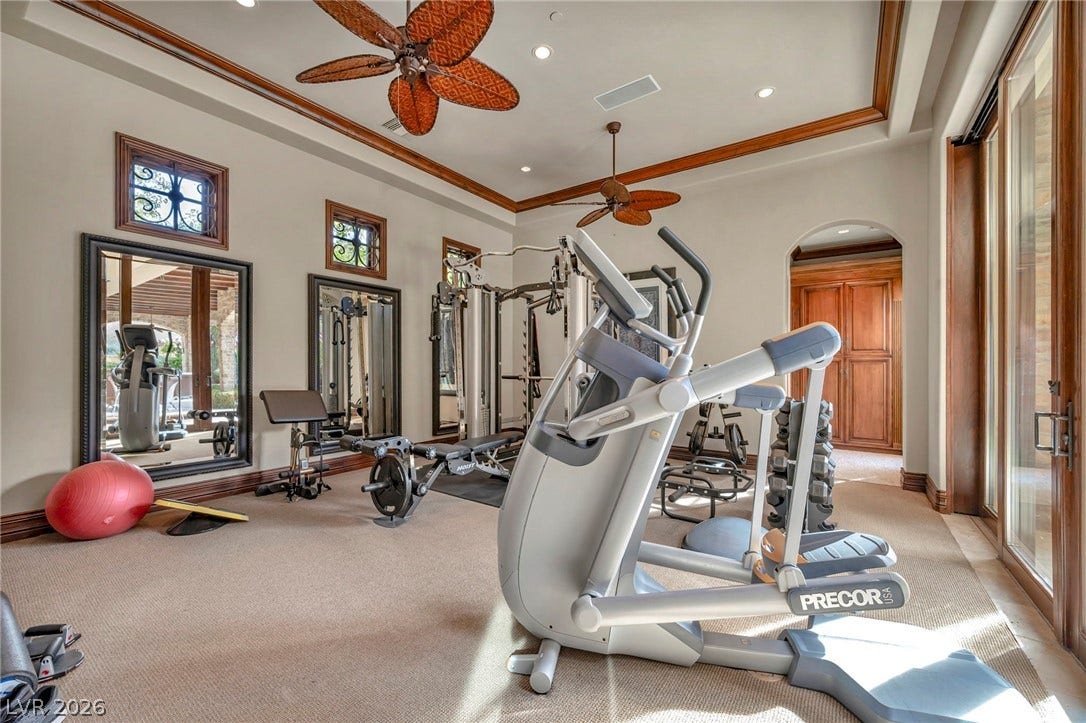 1793 Anelli Court, Henderson, NV 89012 High tray ceilings and warm wood trim frame this home fitness space.