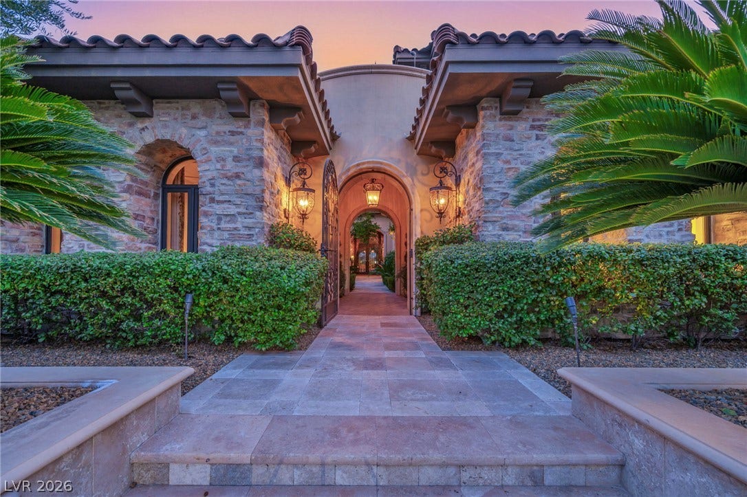 1793 Anelli Court, Henderson, NV 89012 An arched stone entryway leads into a private courtyard surrounded by lush tropical landscaping.