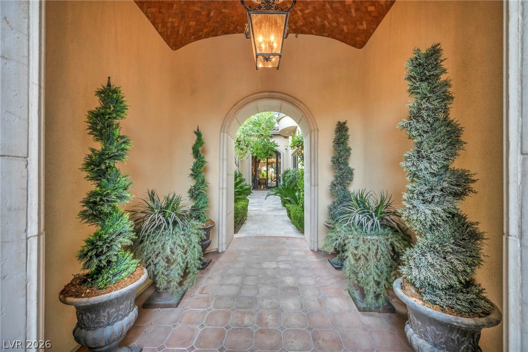 1793 Anelli Court, Henderson, NV 89012 An arched stone entryway leads to a beautifully landscaped courtyard through tiled passageways.