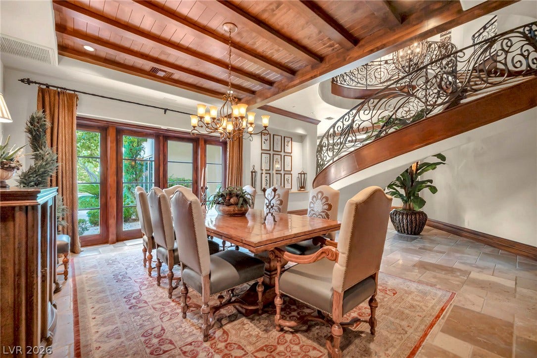 1793 Anelli Court, Henderson, NV 89012 Rich wood plank ceilings and a sweeping wrought iron staircase define this elegant dining space.