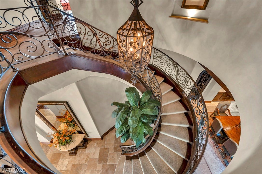 1793 Anelli Court, Henderson, NV 89012 An elegant spiral staircase features ornate wrought iron railings and polished wood trim.