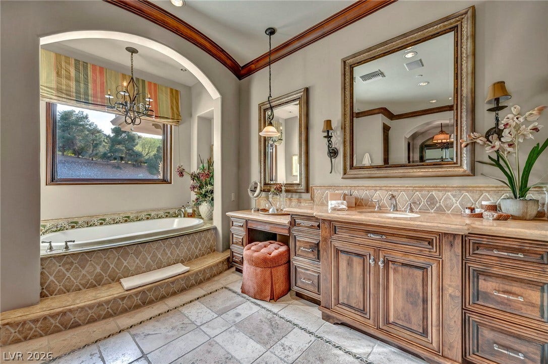 1793 Anelli Court, Henderson, NV 89012 Rich wood cabinetry and a deep soaking tub create a luxurious bathroom retreat.