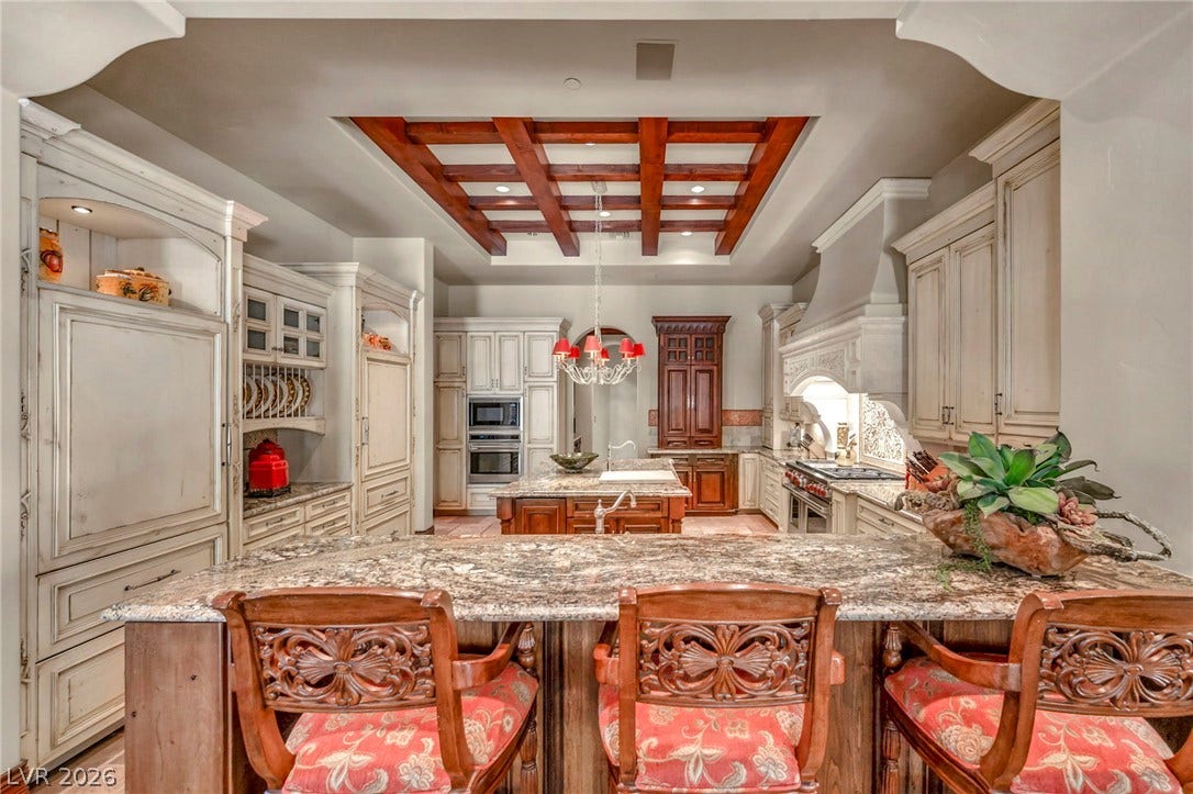 1793 Anelli Court, Henderson, NV 89012 A customized wooden ceiling detail anchors this gourmet kitchen finished with extensive stone countertops.