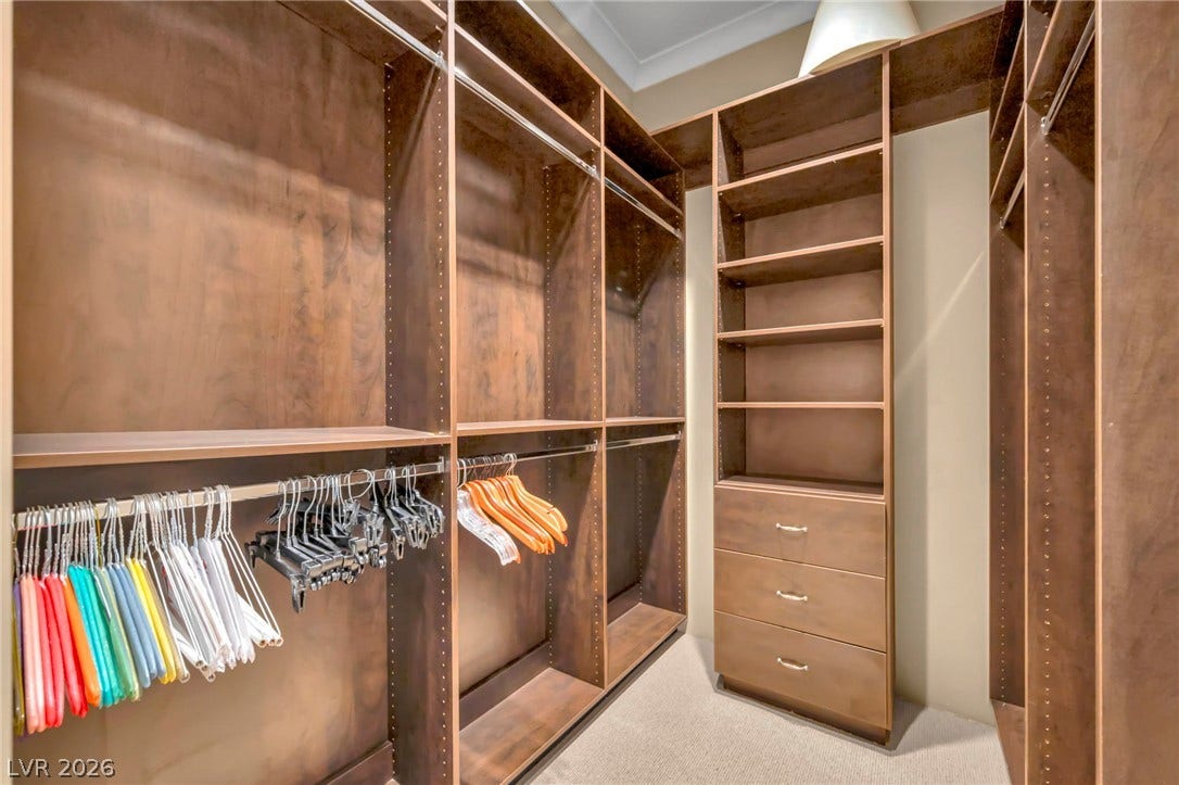 1793 Anelli Court, Henderson, NV 89012 Rich wood built-ins and custom shelving maximize storage in this spacious walk-in closet.