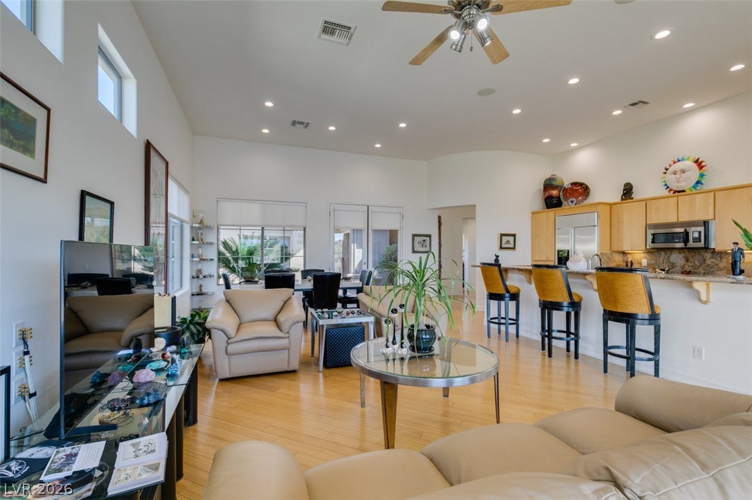 51 E Braelinn Drive, Henderson, NV 89052 Recessed lighting and warm wood flooring enhance this expansive open-concept living and dining area.